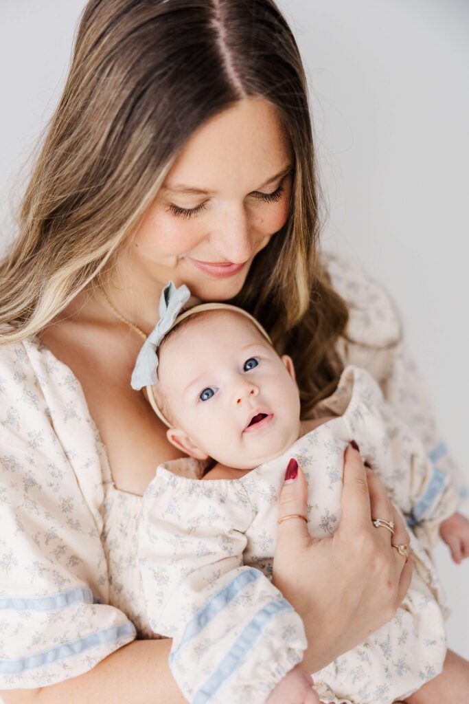 mom holding baby while she stares up at the camera