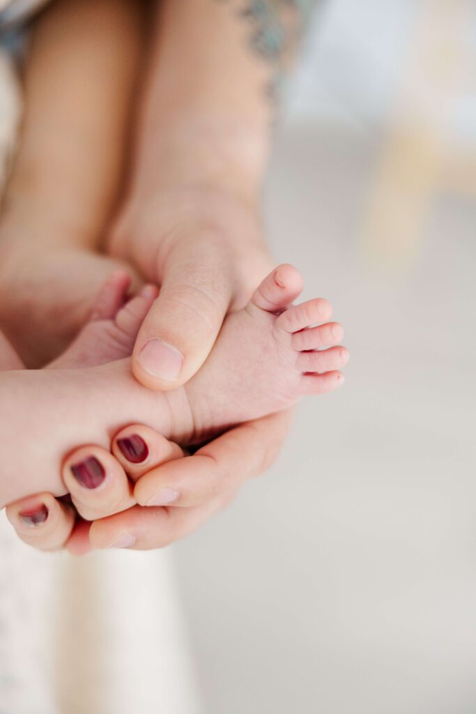 mom and dad holding baby's foot in their hands