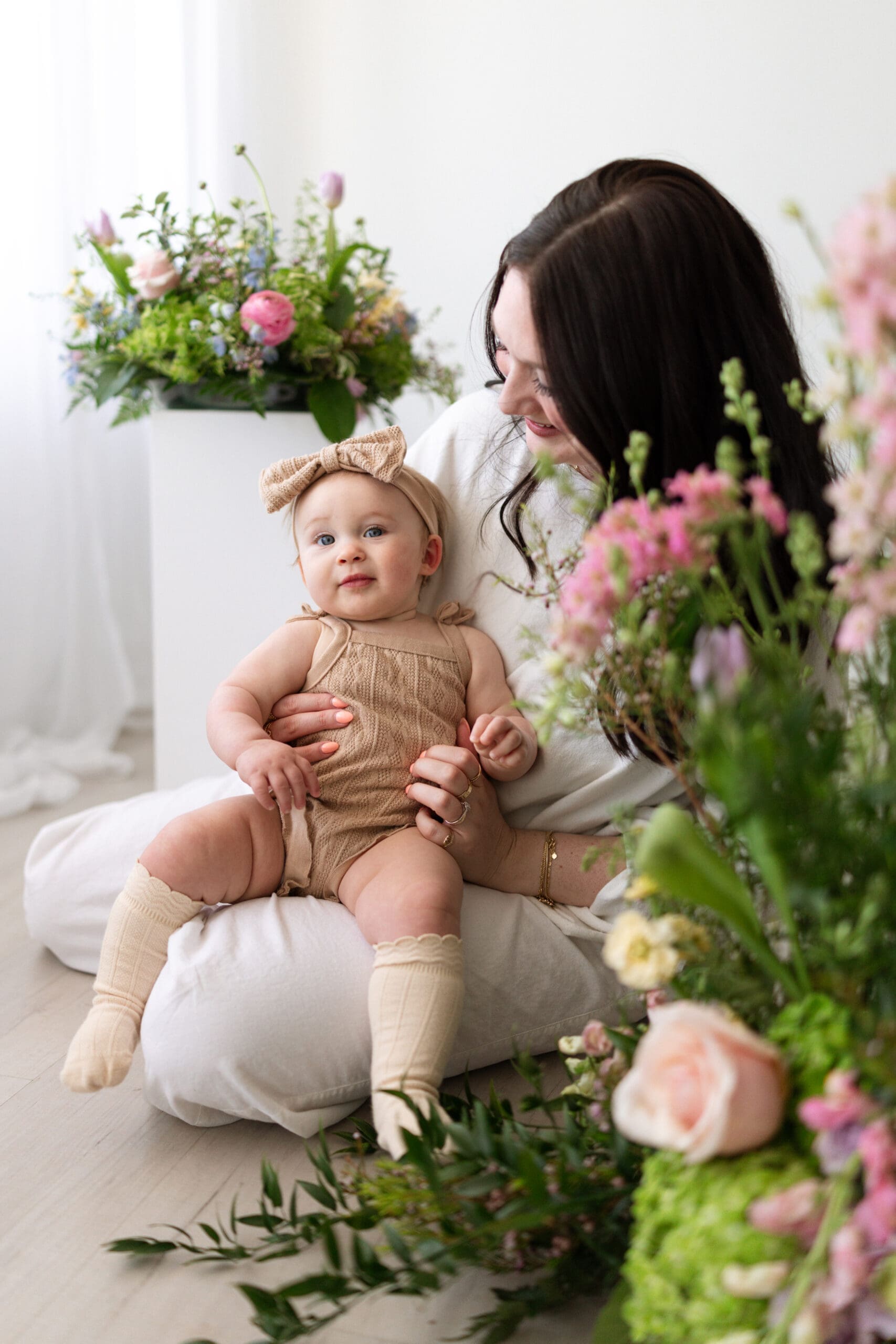 mom and baby with floral arrangements around them